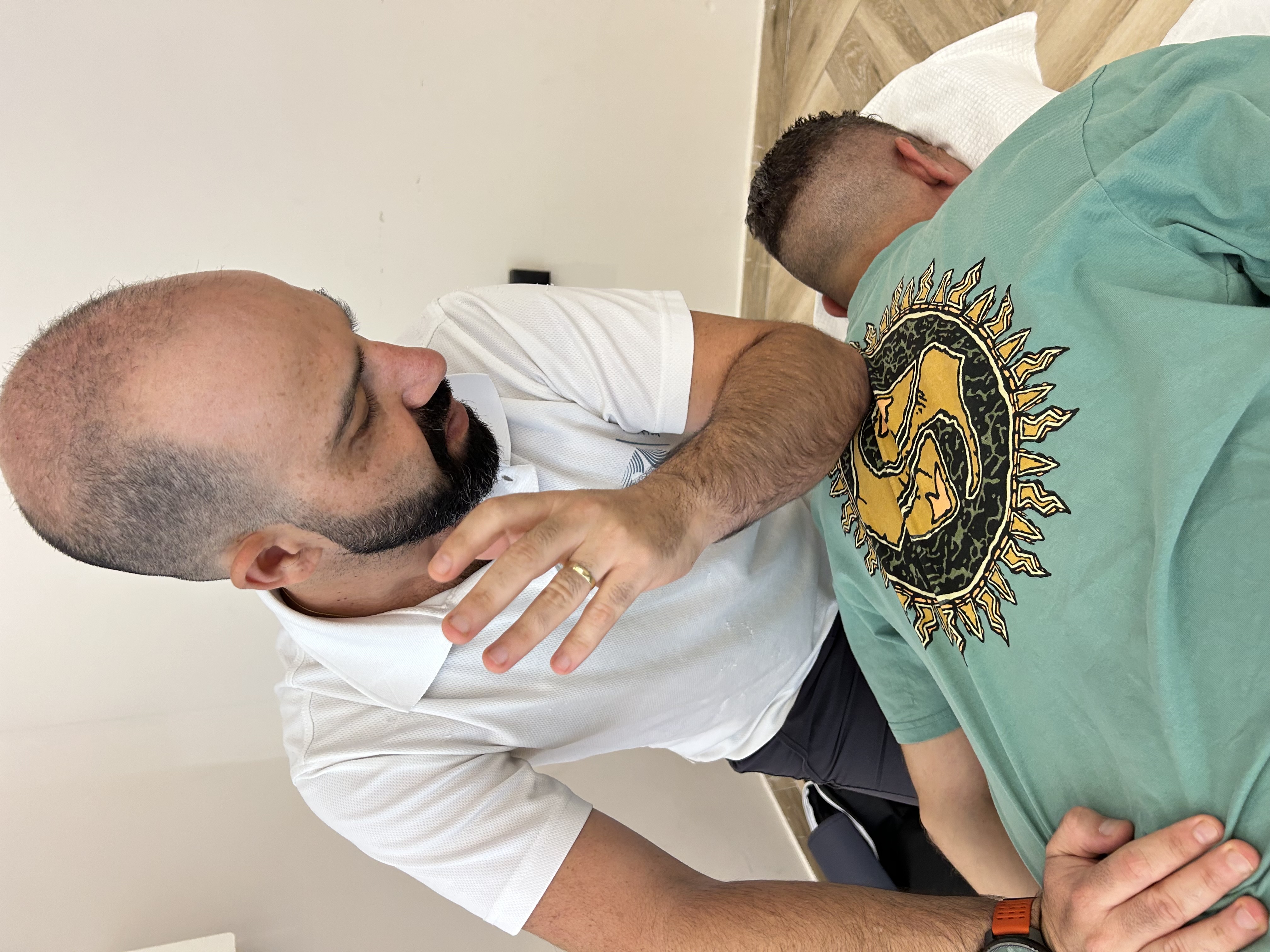 עידן עזיזה מעניק טיפול טווינא למטופל בקליניקה